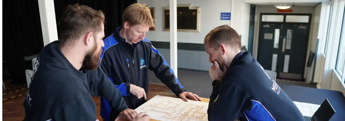 Security engineers at a school planning a fire alarm installation