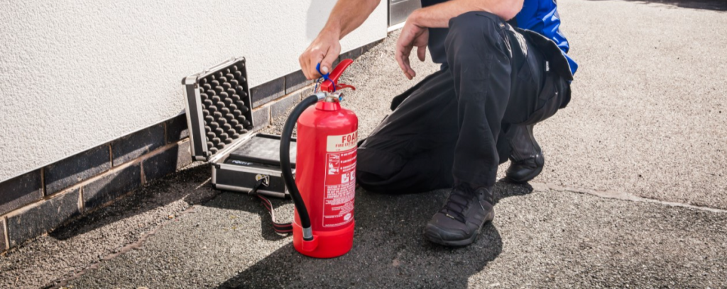 A Mercury employee installs a fire extinguisher