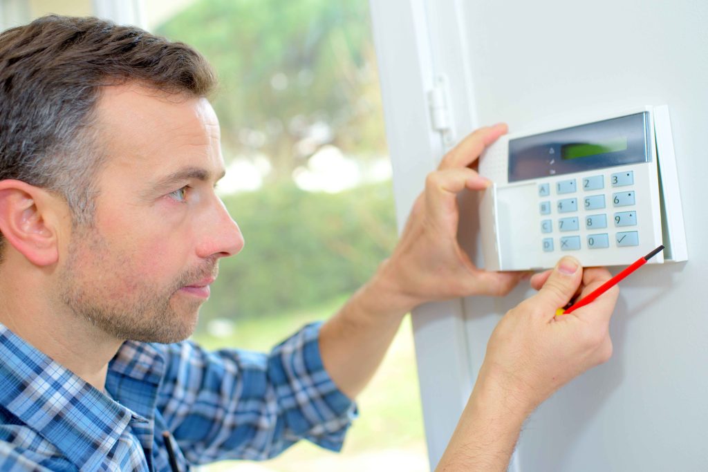 A man uses an intruder alarm system